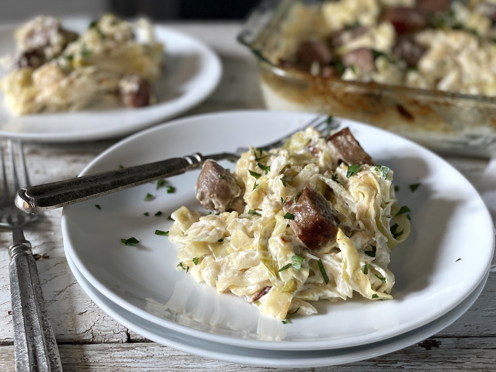 Sausage with cabbage noodles in Alfredo sauce on plate 