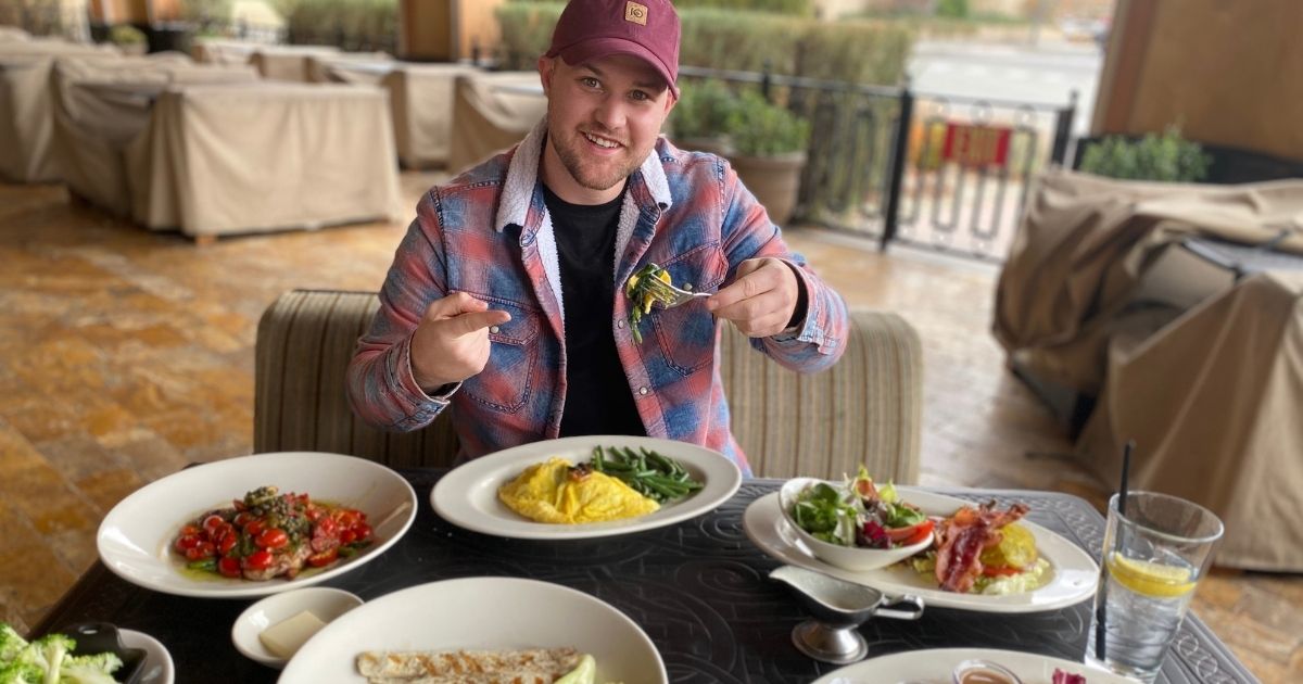 man sitting at the Cheesecake Factory with dishes on the table