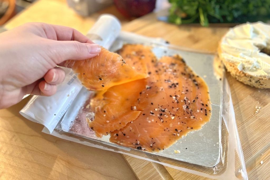 Lifting up a slice of Trader Joe's Everything but the Bagel salmon