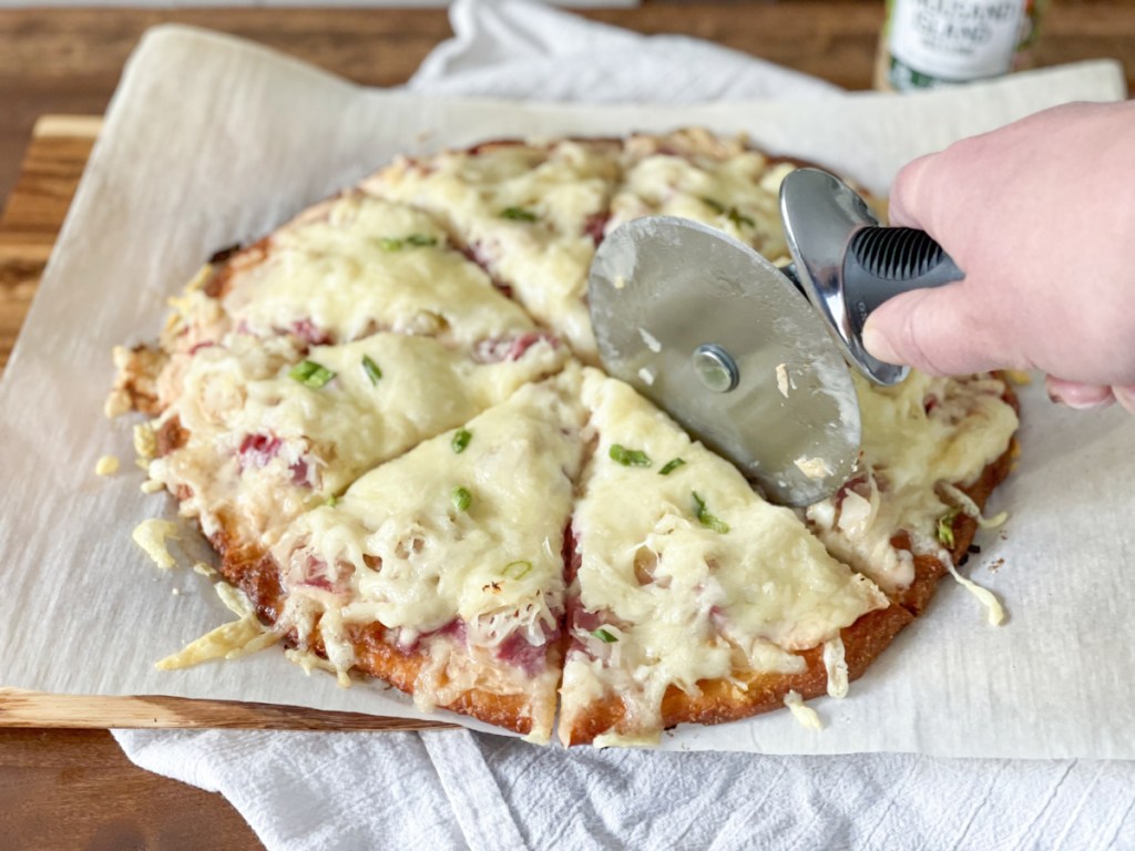 slicing keto reuben pizza