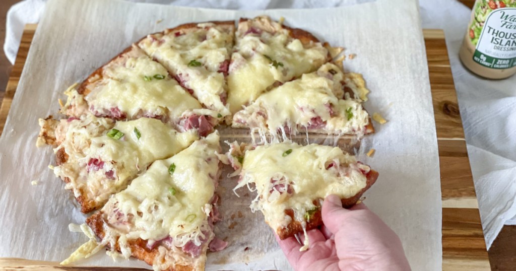 taking a slice of keto reuben pizza