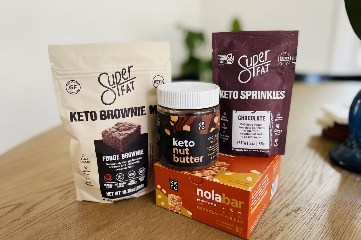 Perfect Keto nut butter, brownie mix, sprinkles, and Nola bars on table