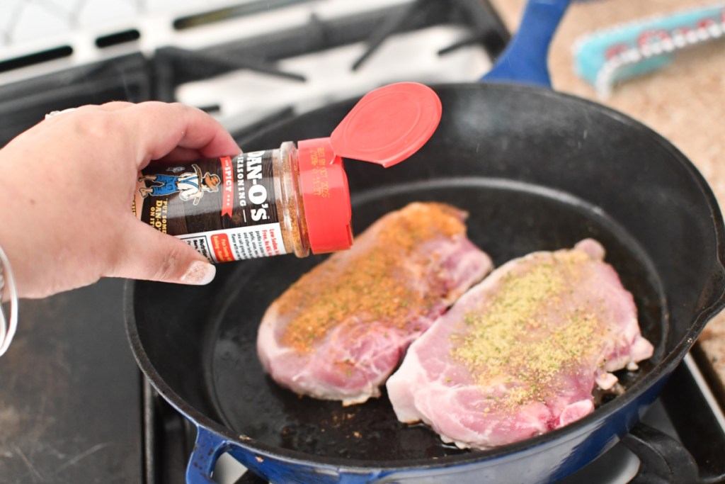 seasoning pork chops in a cast iron skillet