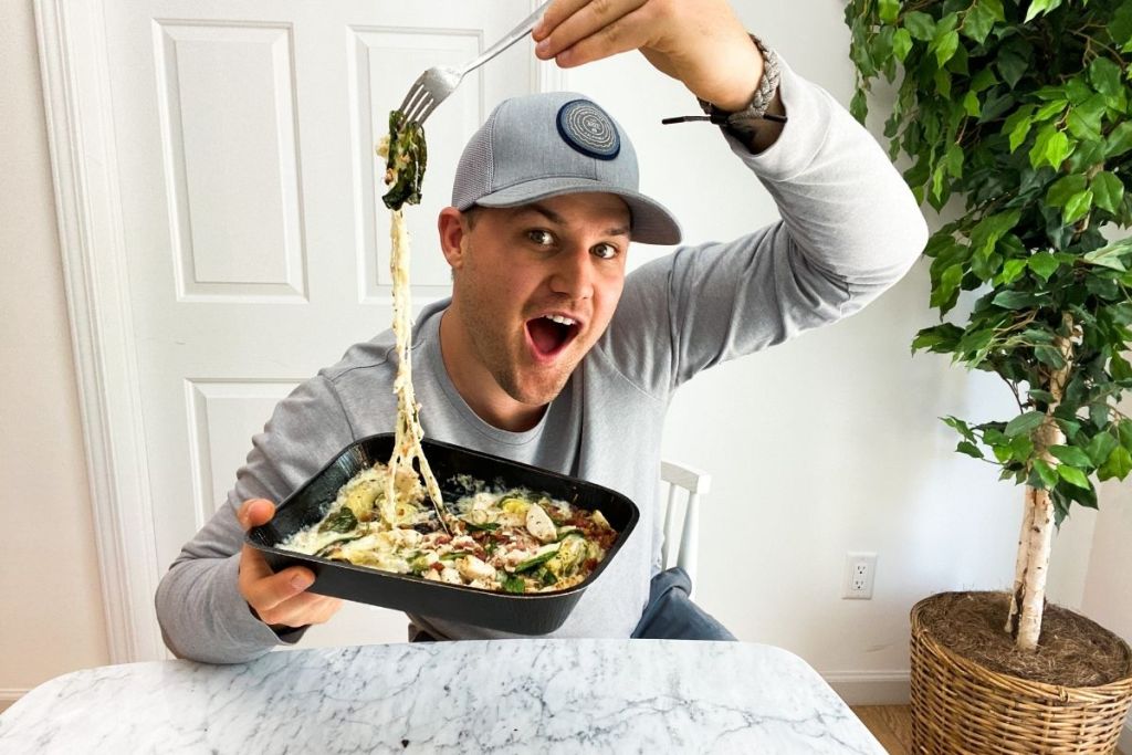 man holding up a fork with keto pizza