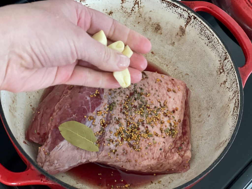 adding garlic to a dutch oven