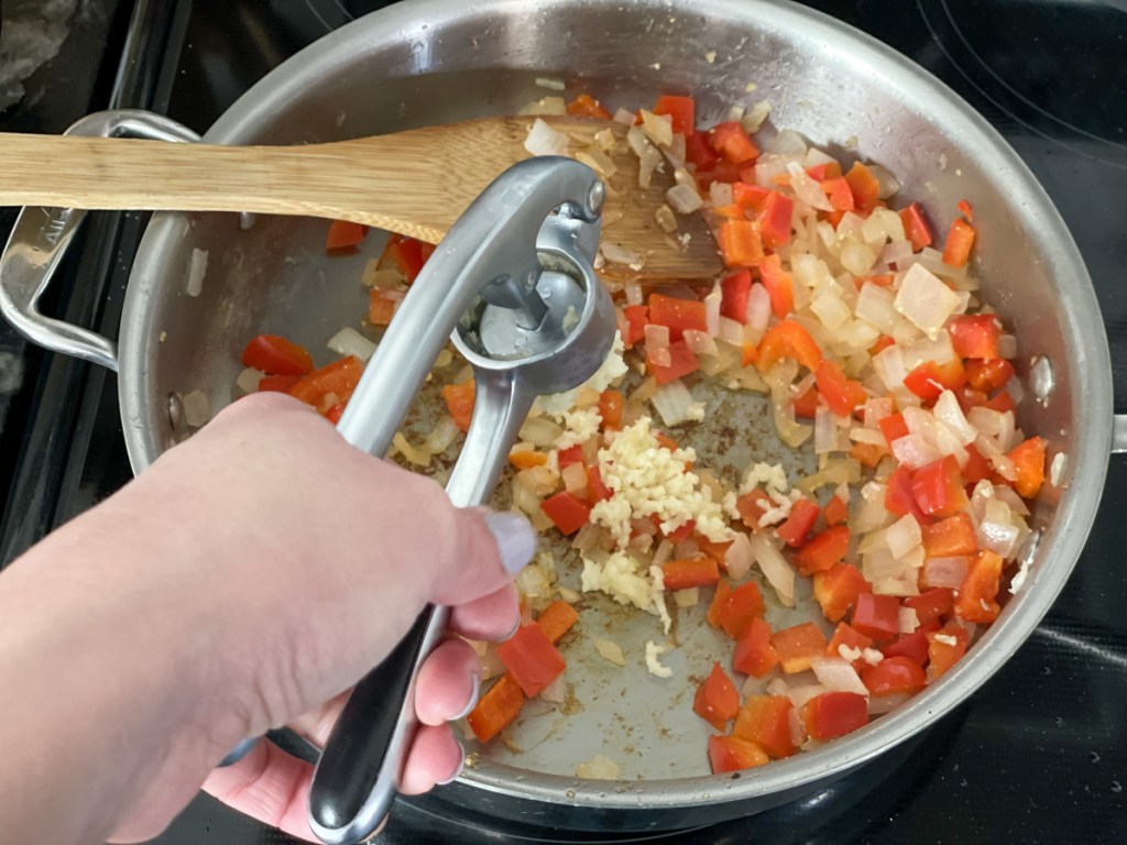 adding garlic to a skillet 