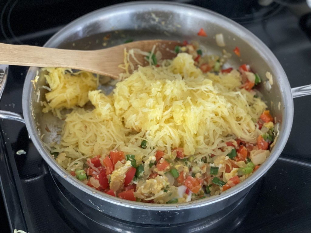 adding spaghetti squash to a skillet 