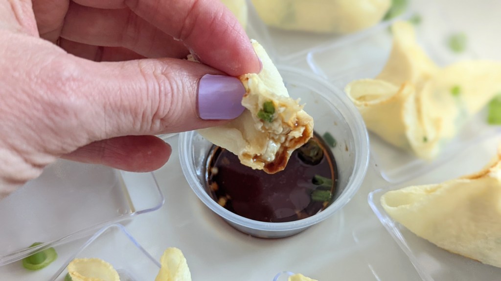 dipping keto wontons in a sauce
