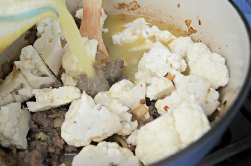 adding broth to zuppa toscana soup