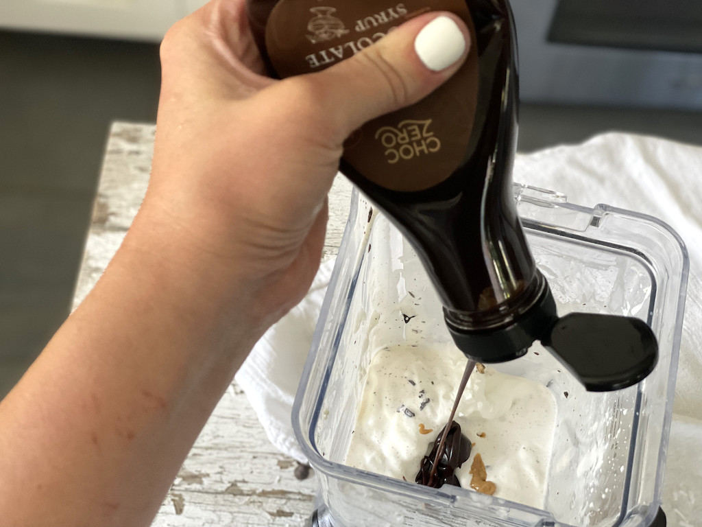 Adding ChocZero keto chocolate syrup to blender 