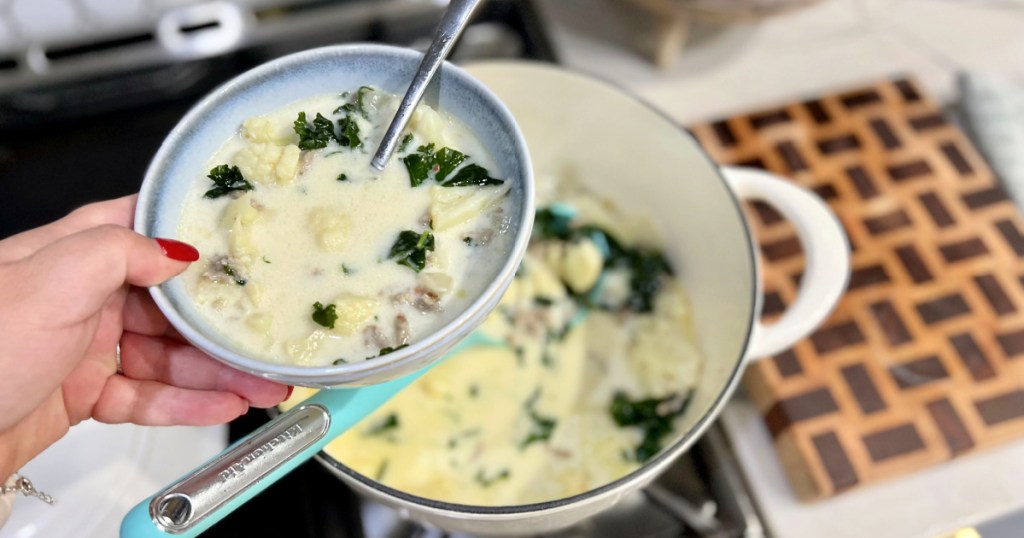 holding a bowl of keto zuppa toscana