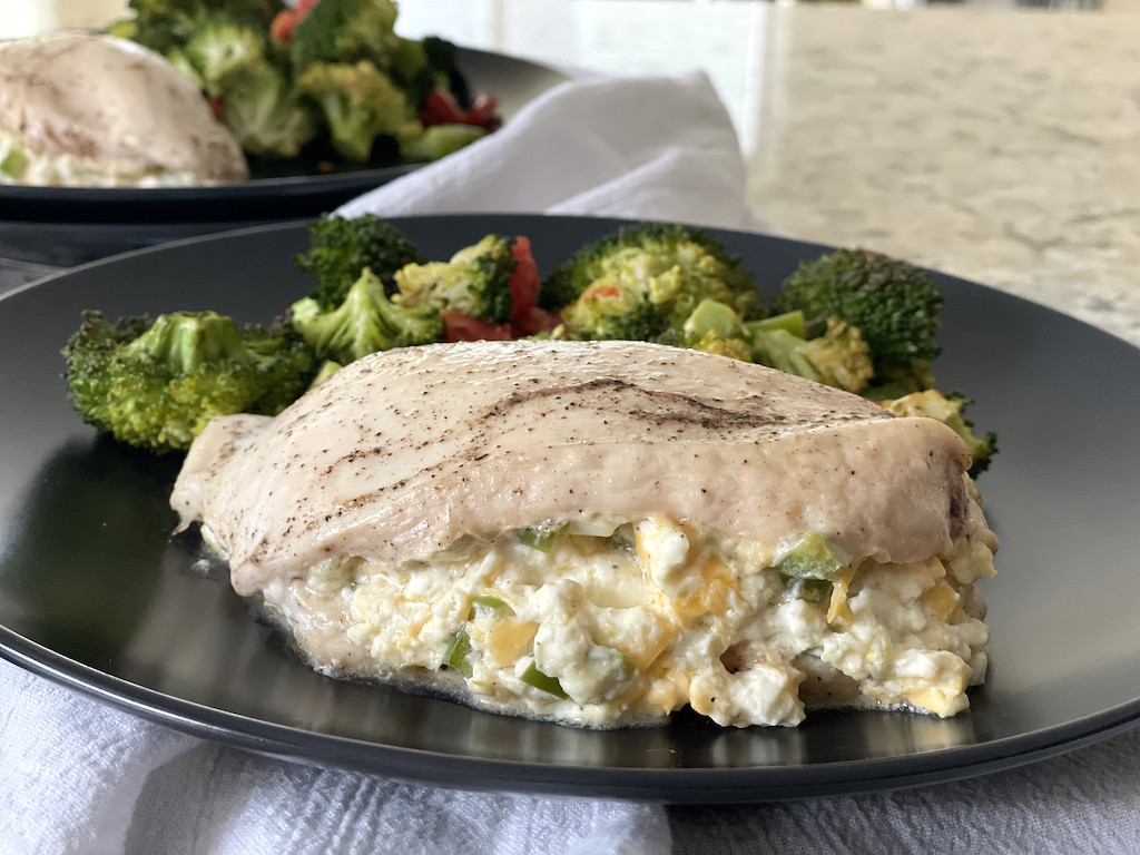 stuffed cream cheese chicken breast on plate with broccoli 