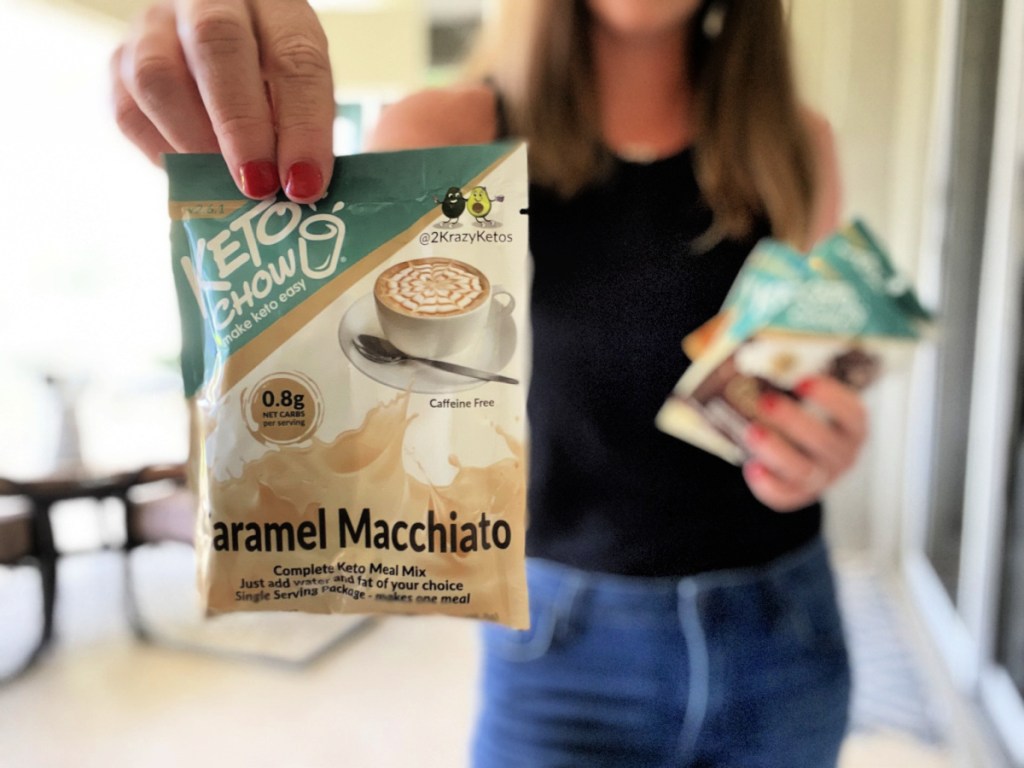 Woman holding up a caramel macchiato meal replacement shake