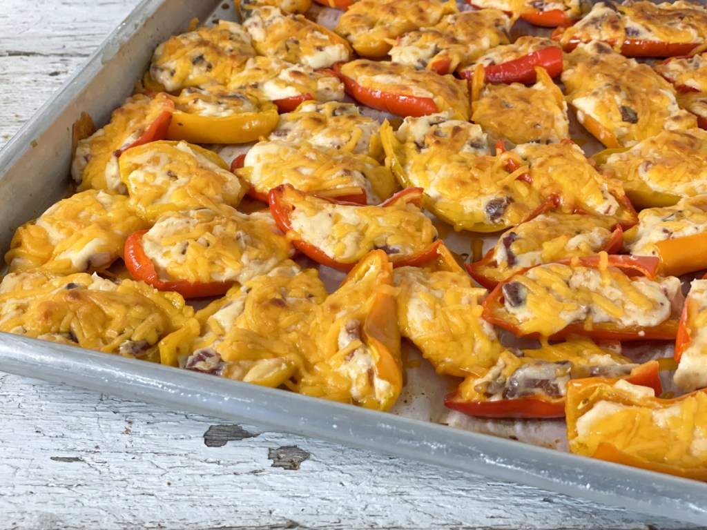 cream cheese stuffed mini peppers on a baking sheet