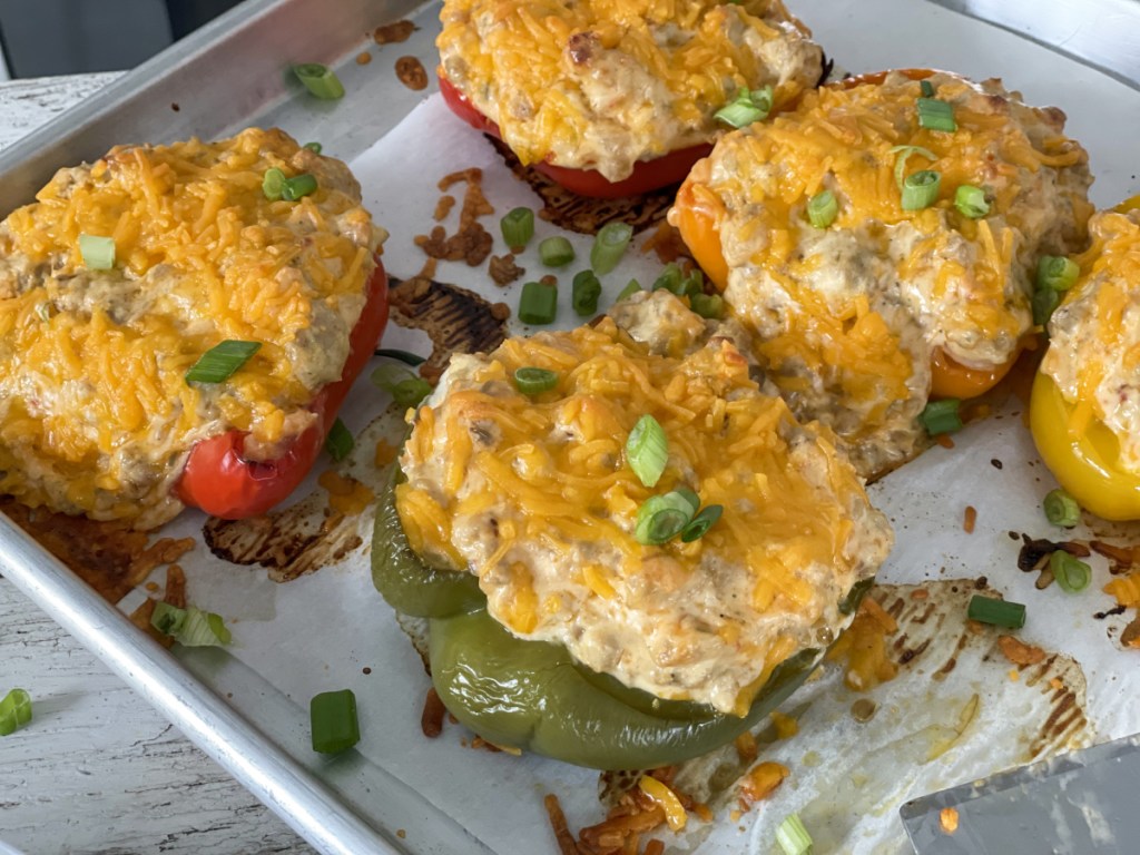 cream cheese and chicken stuffed bell peppers on a baking sheet