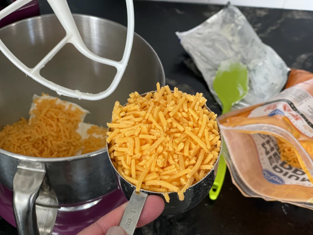 measuring cup full of shredded cheddar 