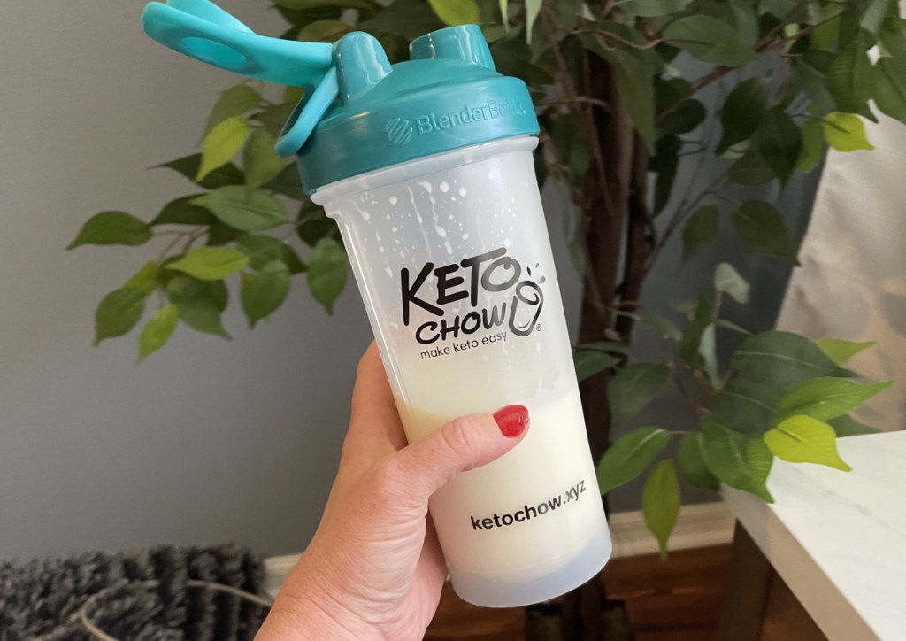Hand holding a keto chow shake in a keto chow bottle