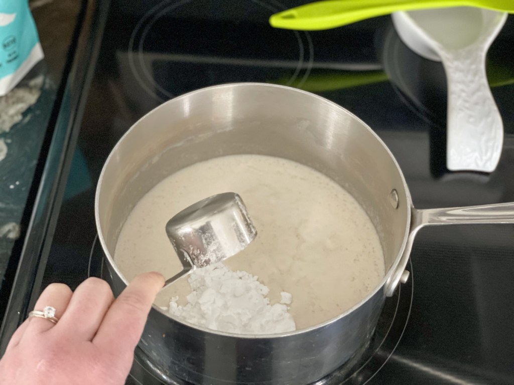 adding sweetener to coconut milk in a saucepan