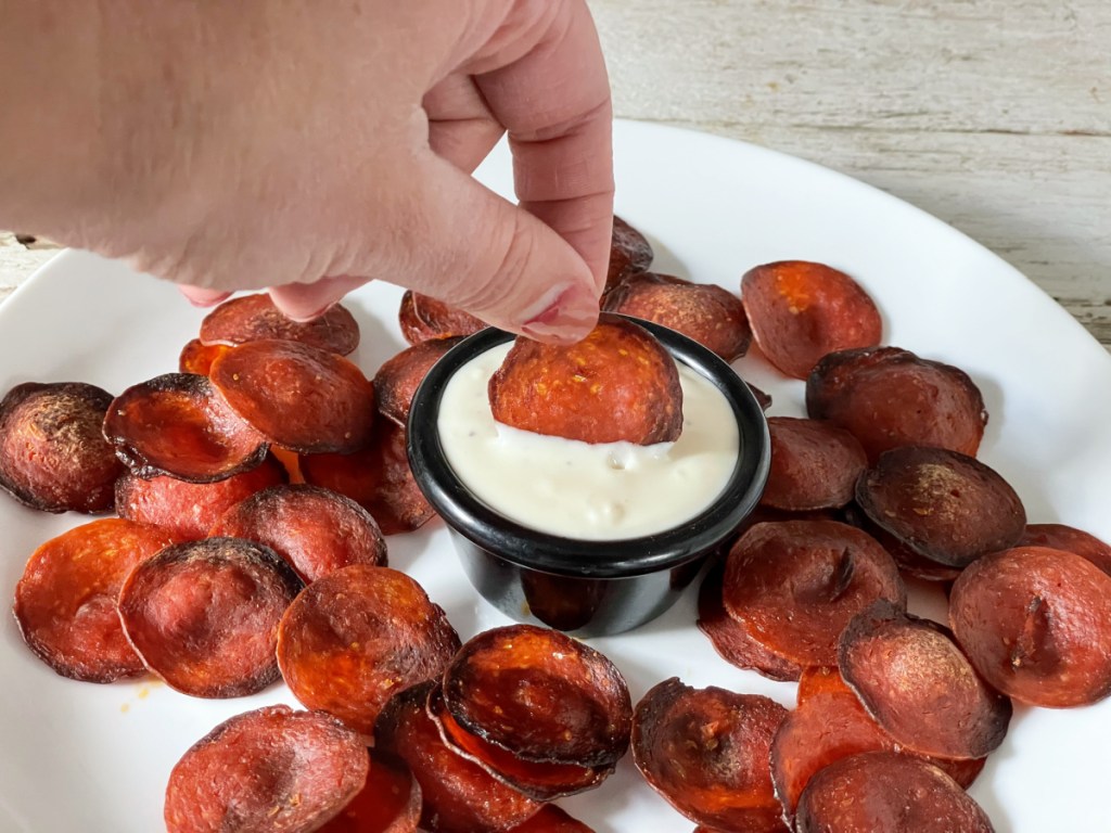 dipping a pepperoni chip in blue cheese 