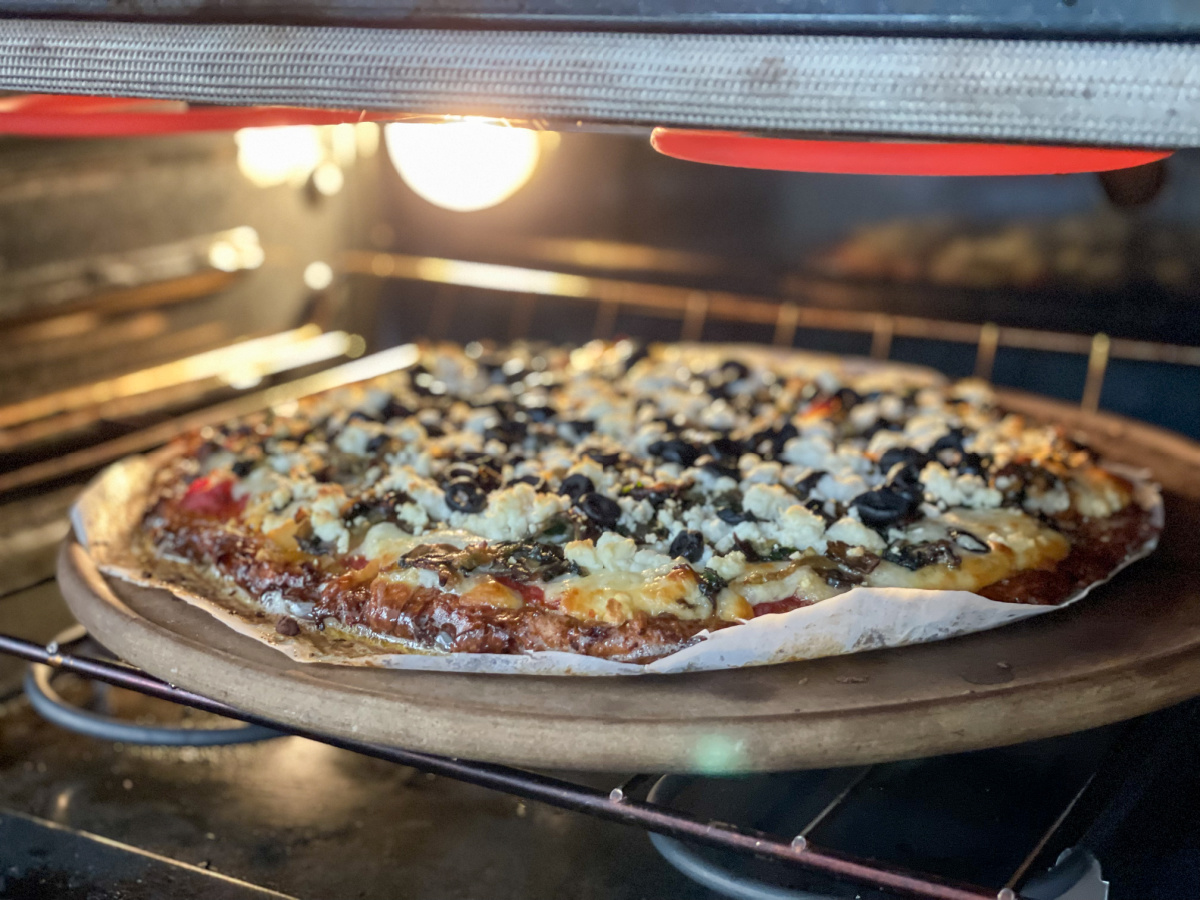 keto sausage crust pizza baking in oven