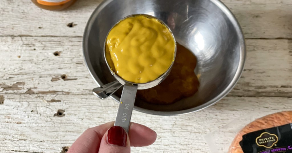 adding mustard to a bowl