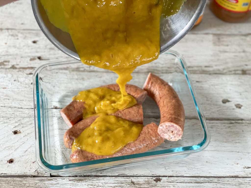 pouring apricot mustard glaze on sausage 