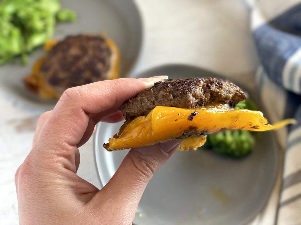 holding homemade flying dutchman burger with cheese