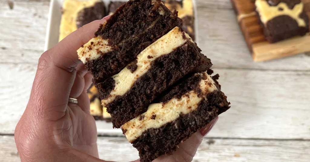 holding stack of keto cream cheese brownies 