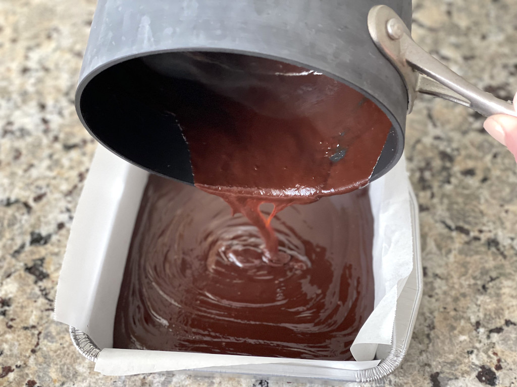 pouring chocolate fudge into pan 