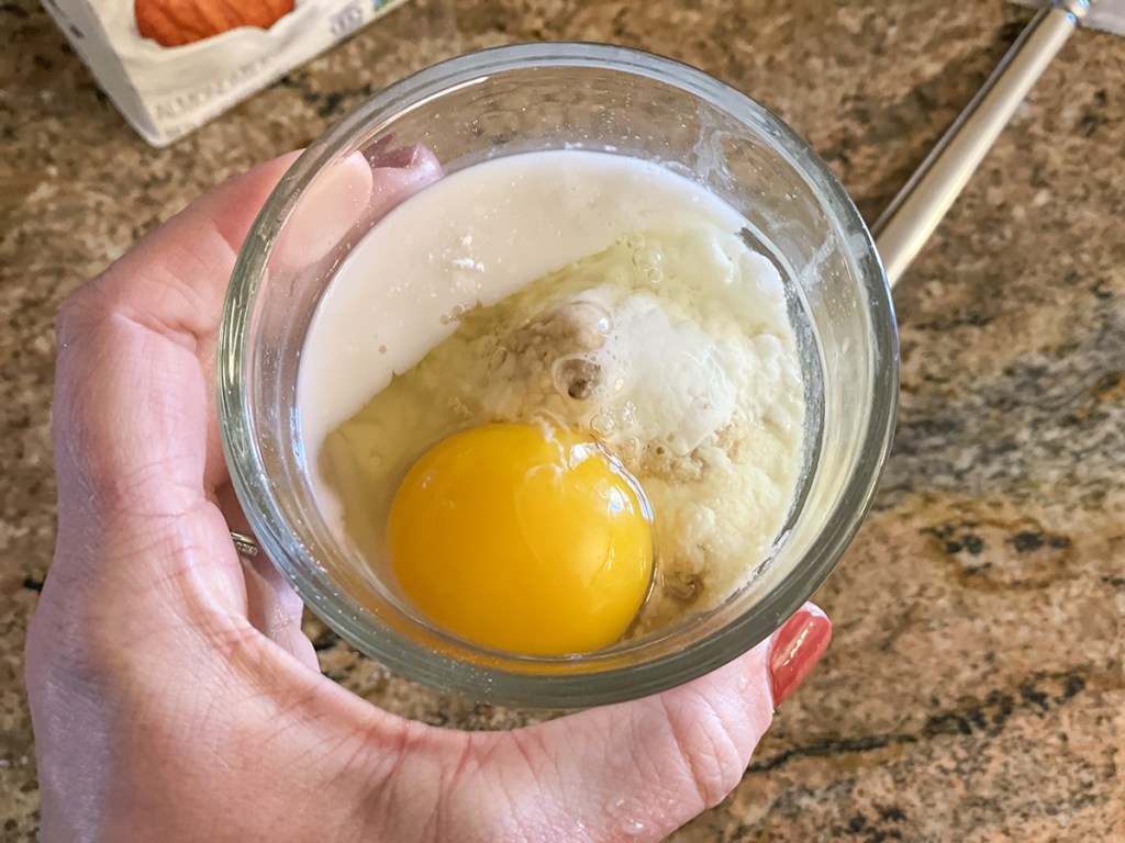 holding a bowl with 90-second keto sweet bread ingredients 