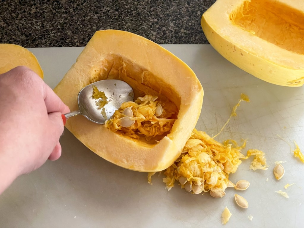 scooping seeds out of spaghetti squash