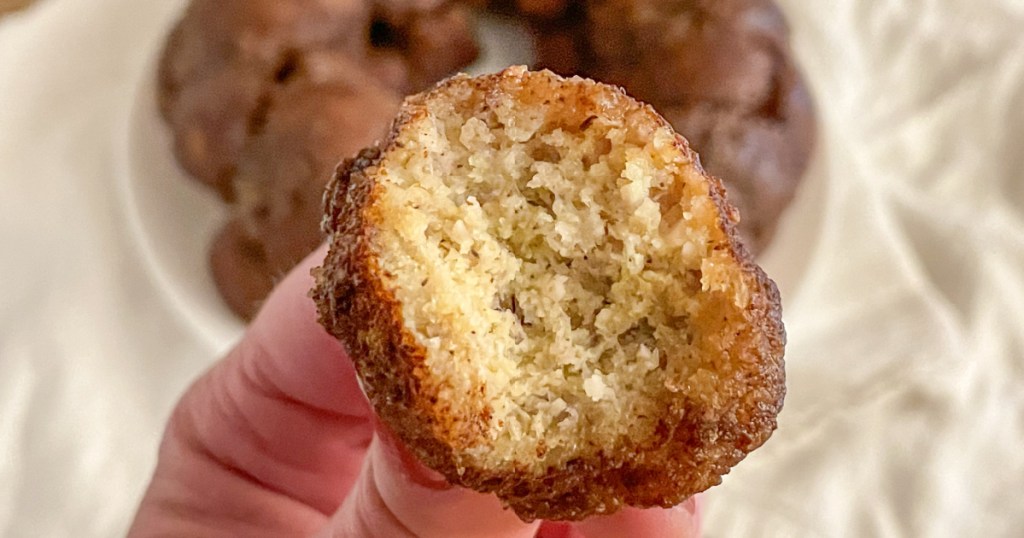 holding a piece of dairy-free monkey bread with a bite out of it