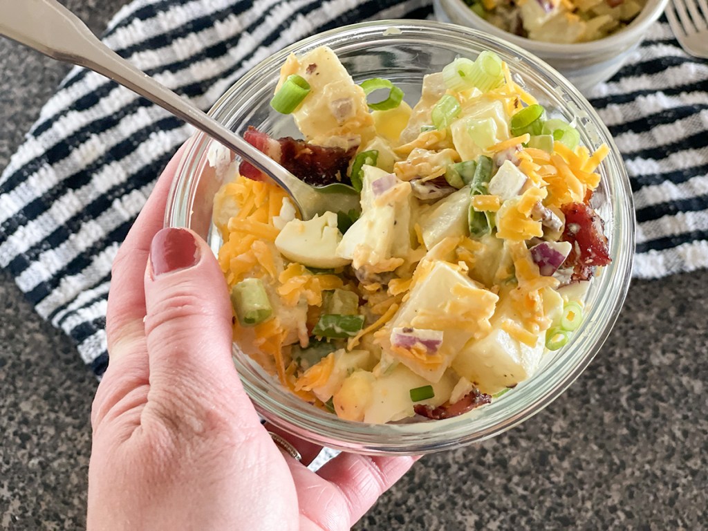 holding a bowl of loaded jicama potato salad 