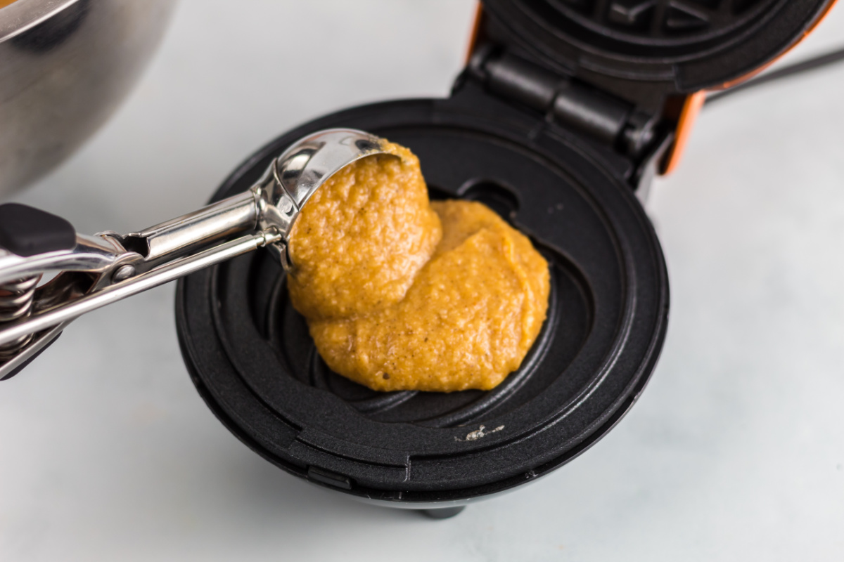 Placing low carb pumpkin batter in a waffle maker