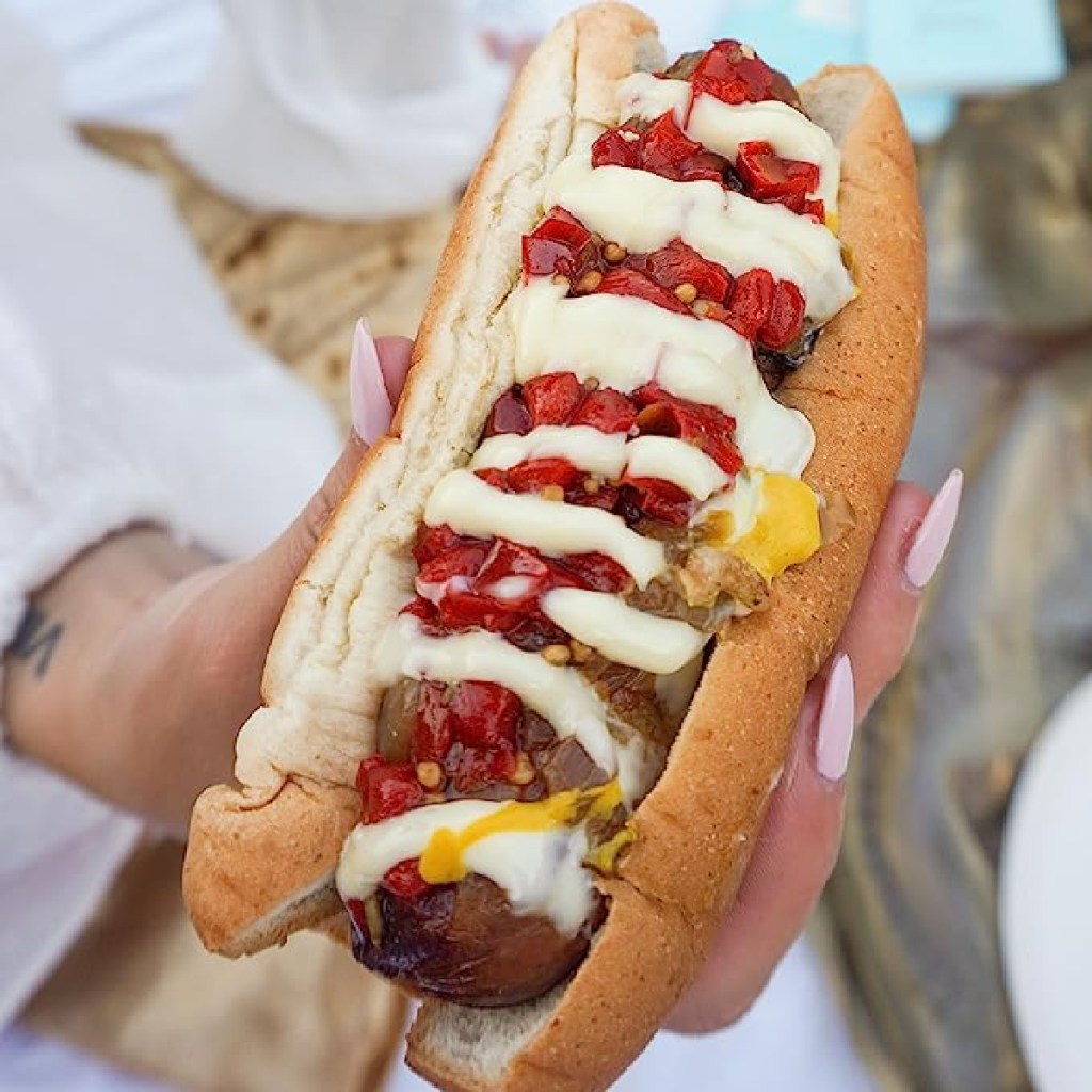 hand holding hero hot dog bun with hot dog