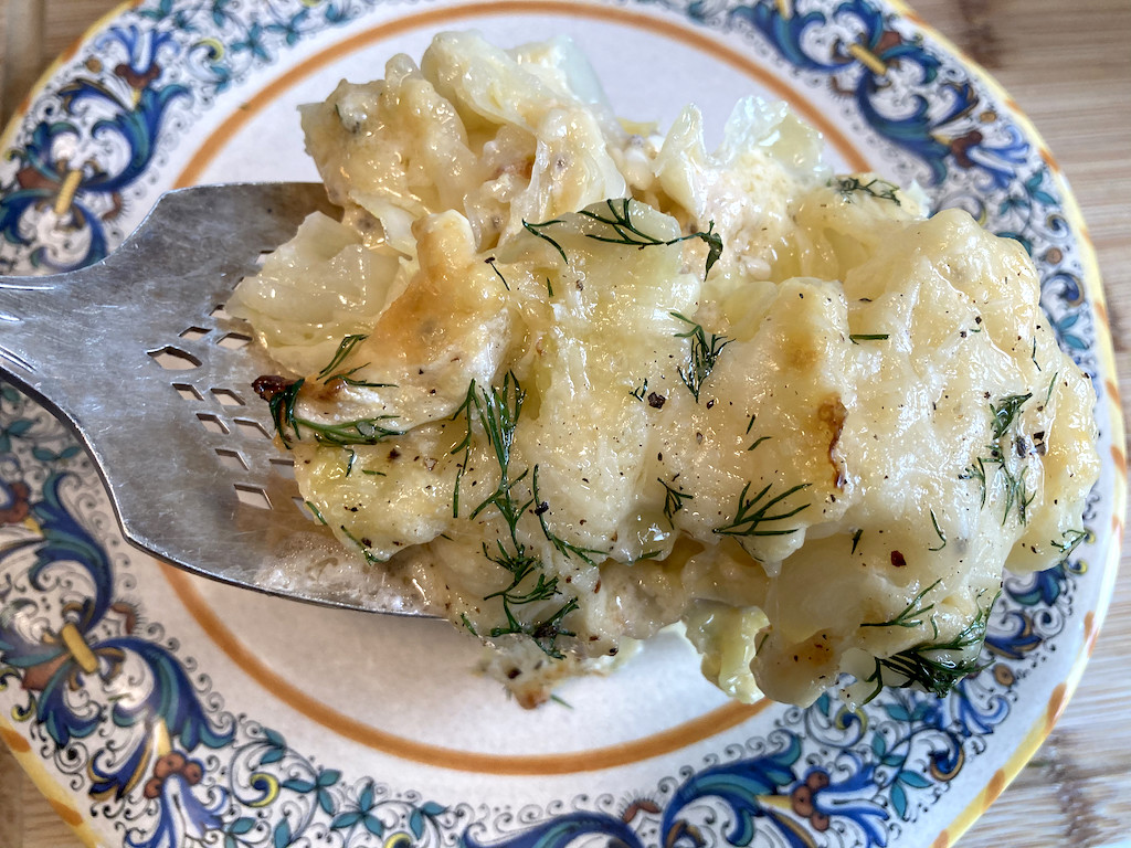 scalloped cabbage casserole being put on plate 