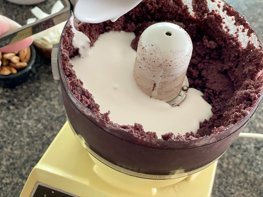 adding coconut milk to acai in food processor 