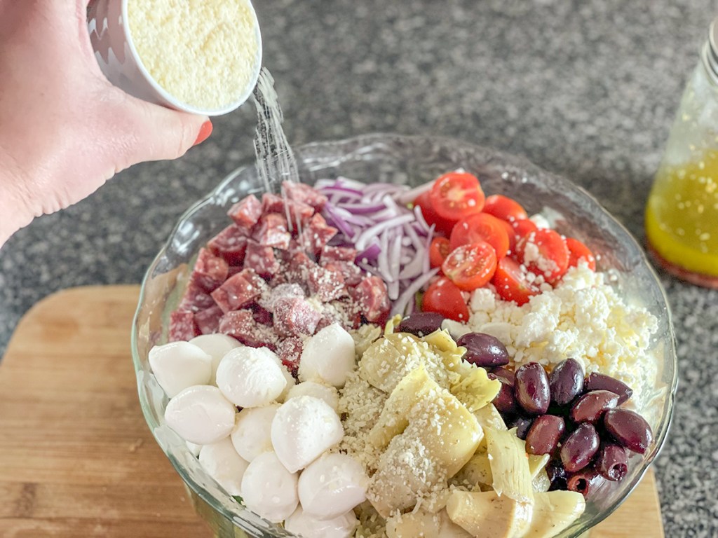 adding grated parmesan to salad 