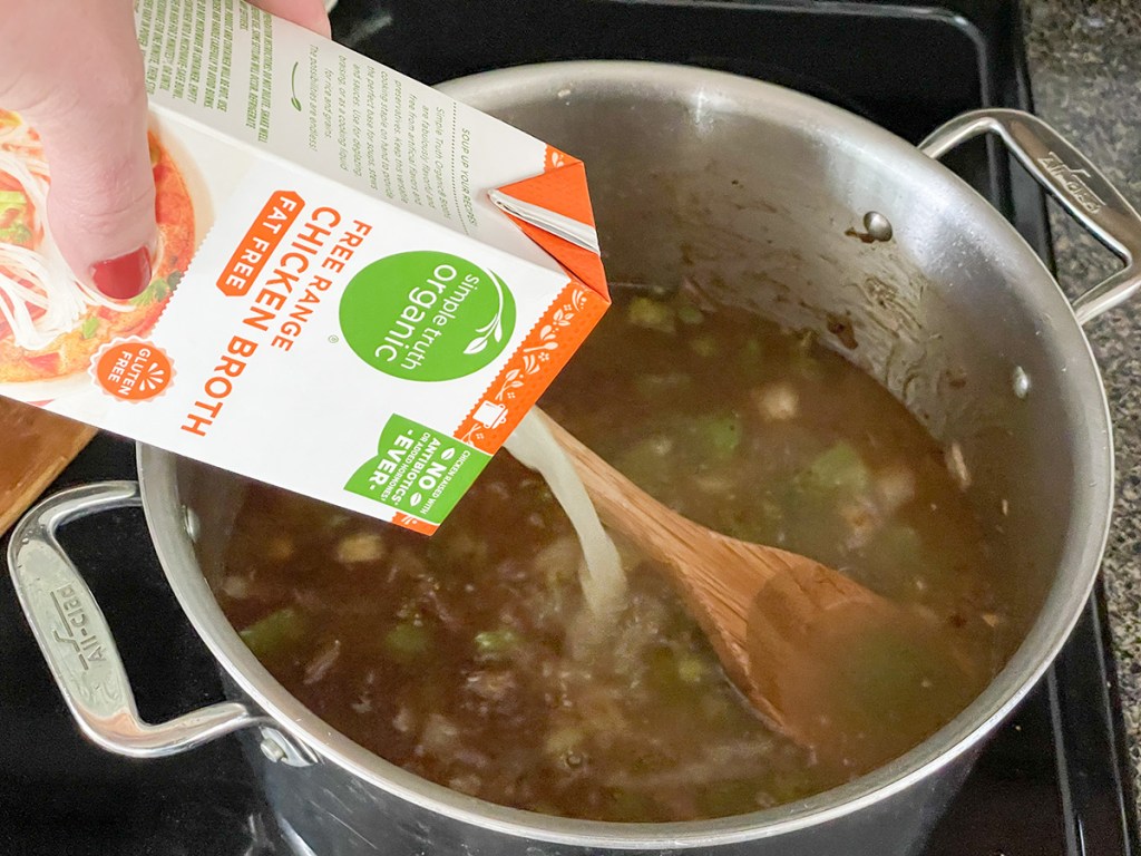 adding broth to a stock pot 