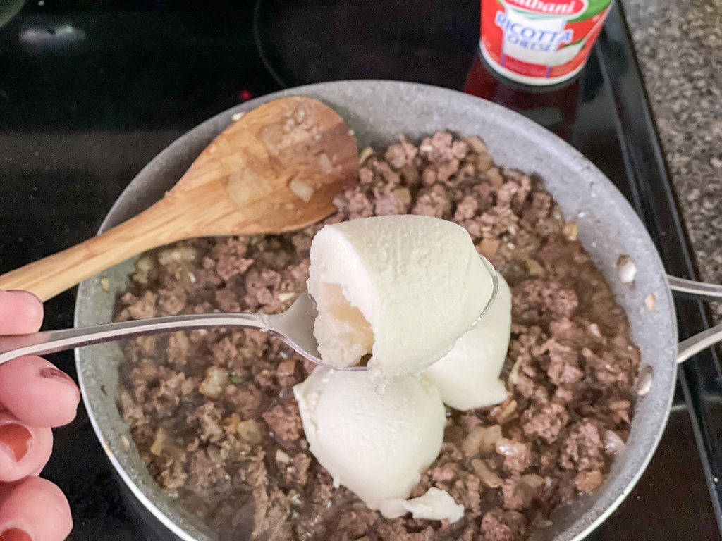 ground beef with ricotta cheese in a skillet
