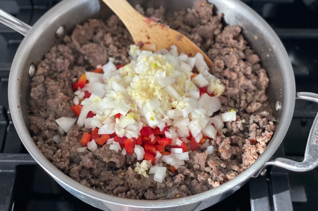 cooking sausage and onions in skillet