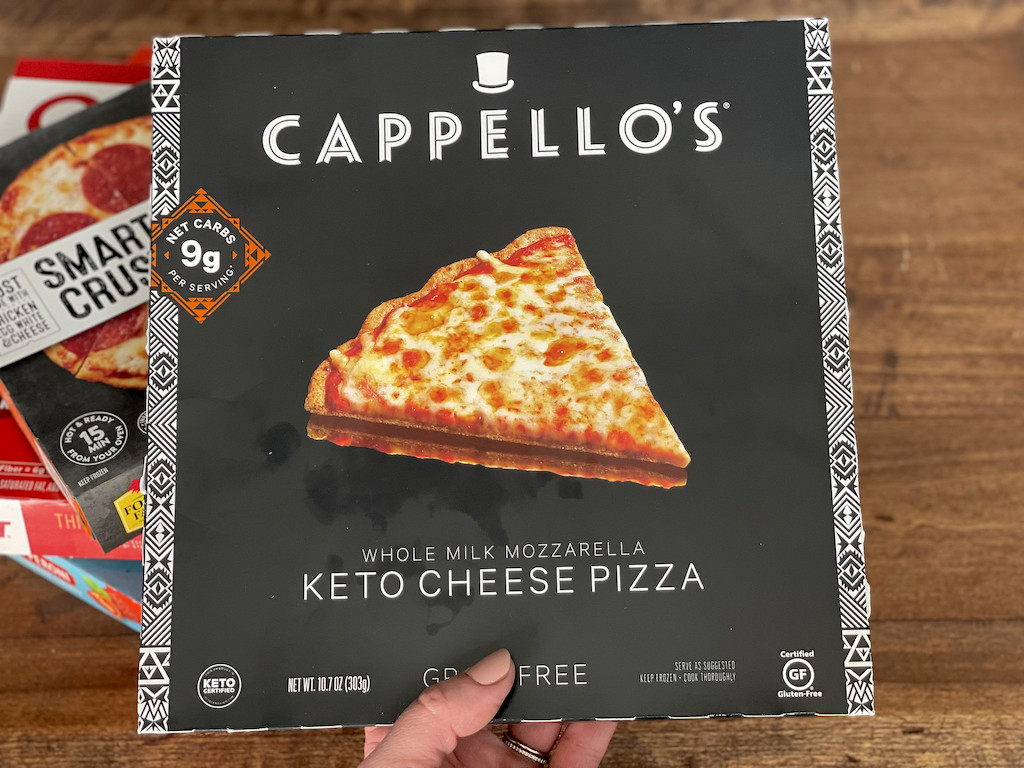 holding Cappello's keto frozen cheese pizza 