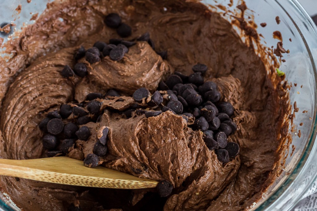 mixing chocolate chips into brownie batter