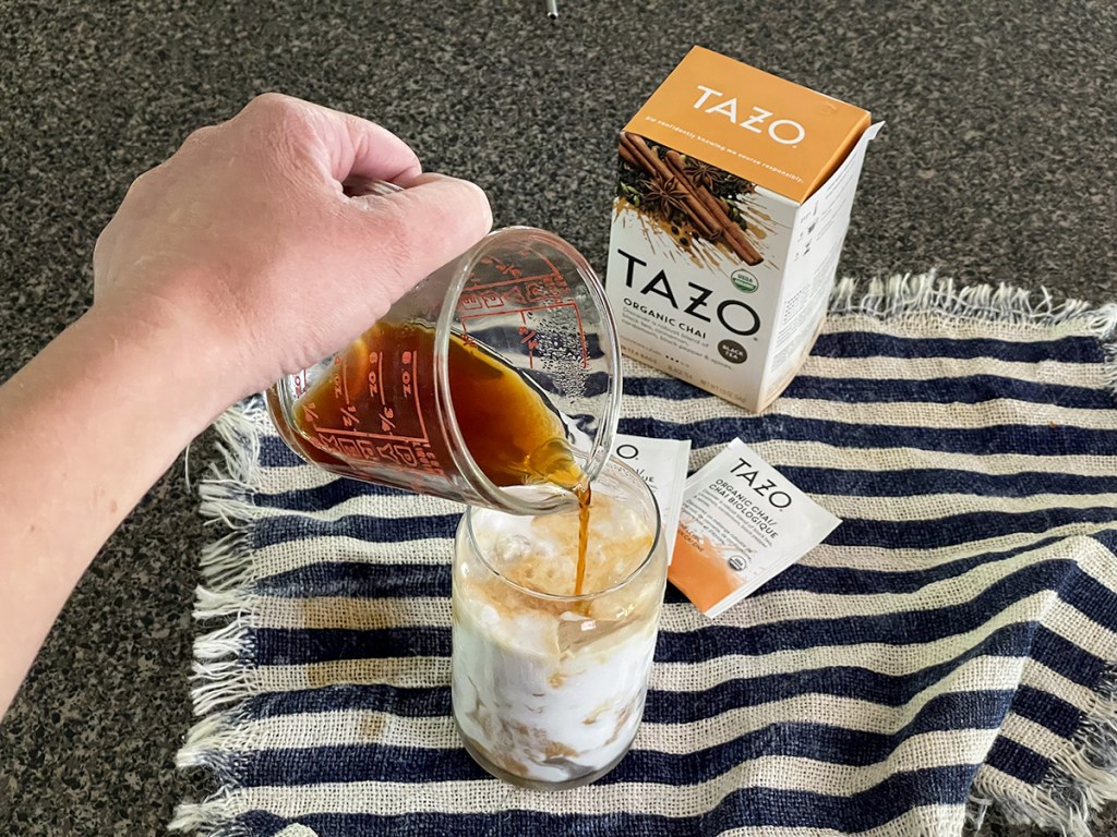 pouring chai tea concentrate into a glass