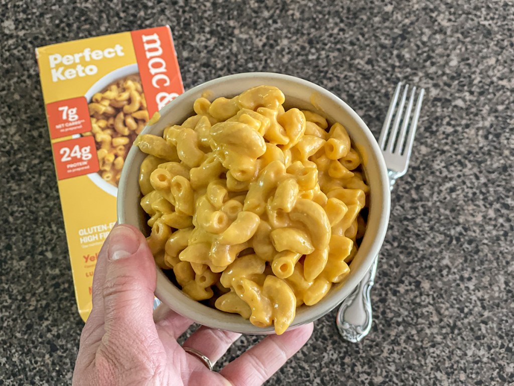 perfect keto Mac & cheese holding a bowl of it