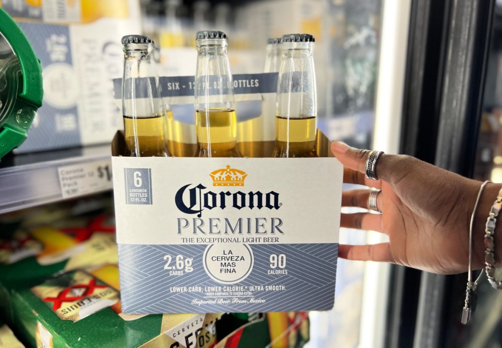 Hand holding a pack of Corona Premier