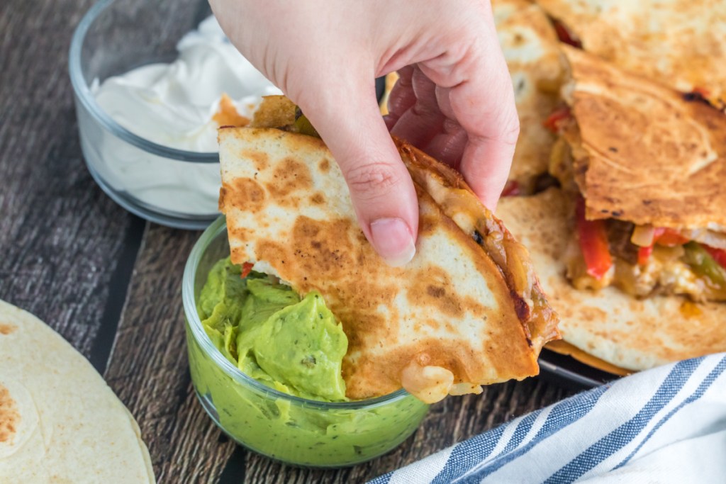 dipping steak quesadilla in guacamole