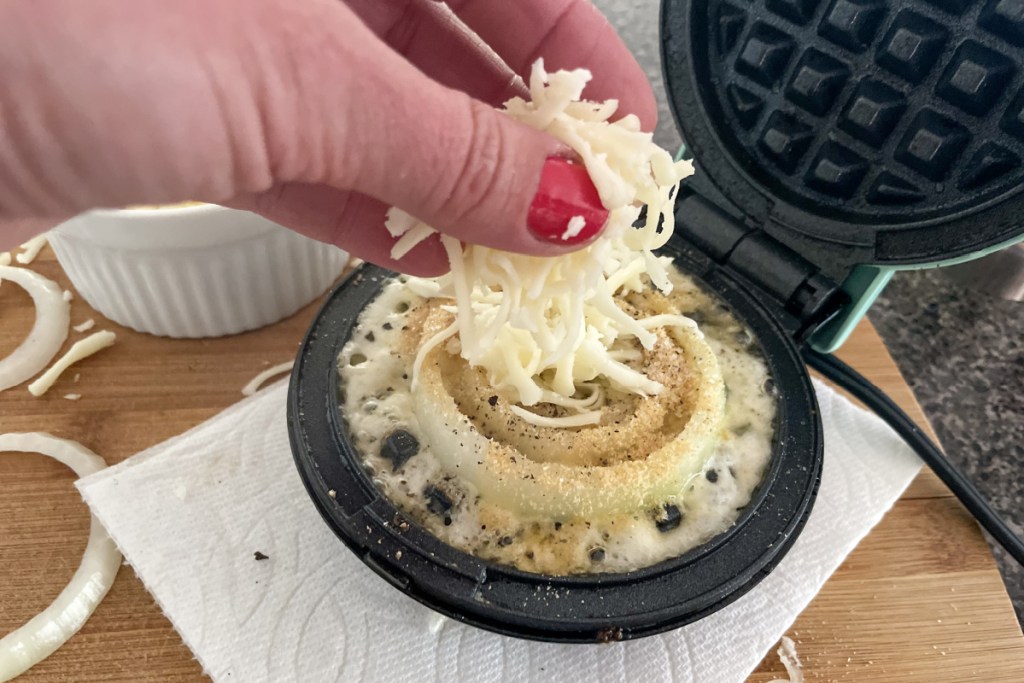 adding cheese to onions in mini waffle maker