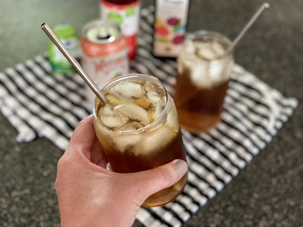 holding a glass of sparkling water and vinegar