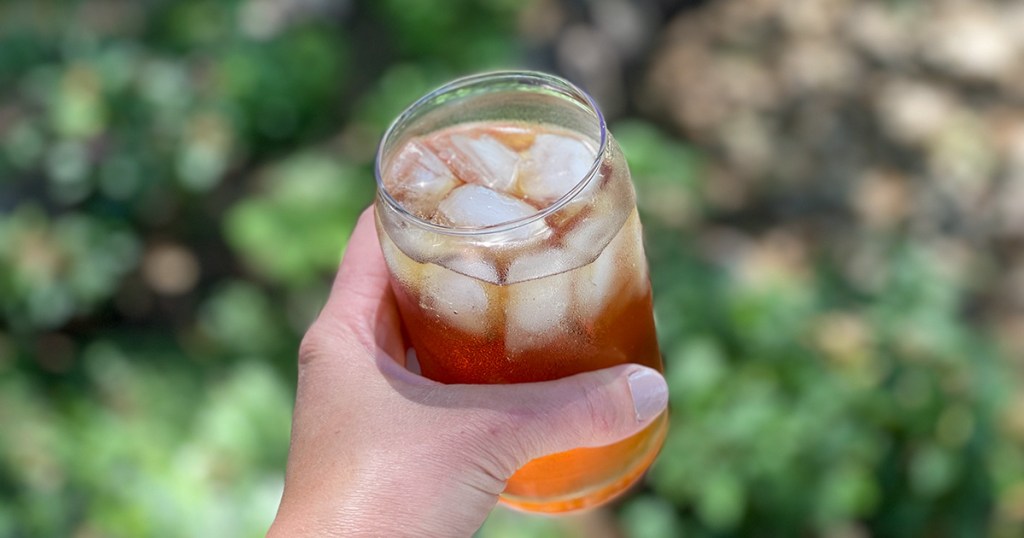 holding a glass of sparkling water and vinegar outside